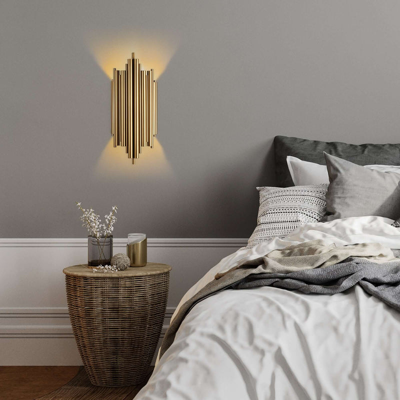 Golden ribbed column wall light with luxurious design and warm glow.