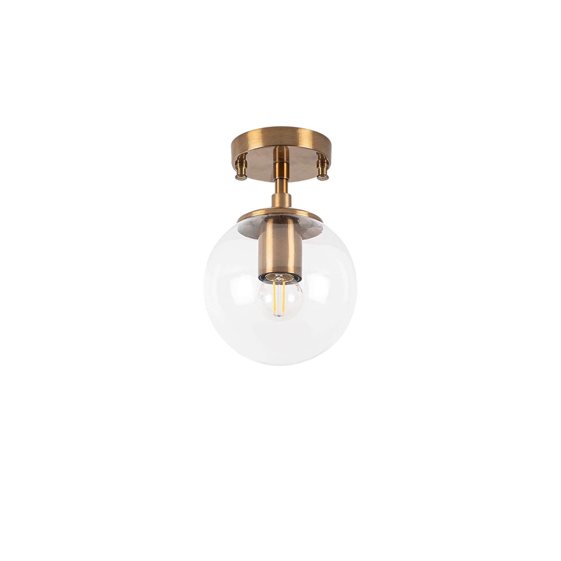 Clear glass globe ceiling light with brass finish, modern simplicity meets vintage charm.