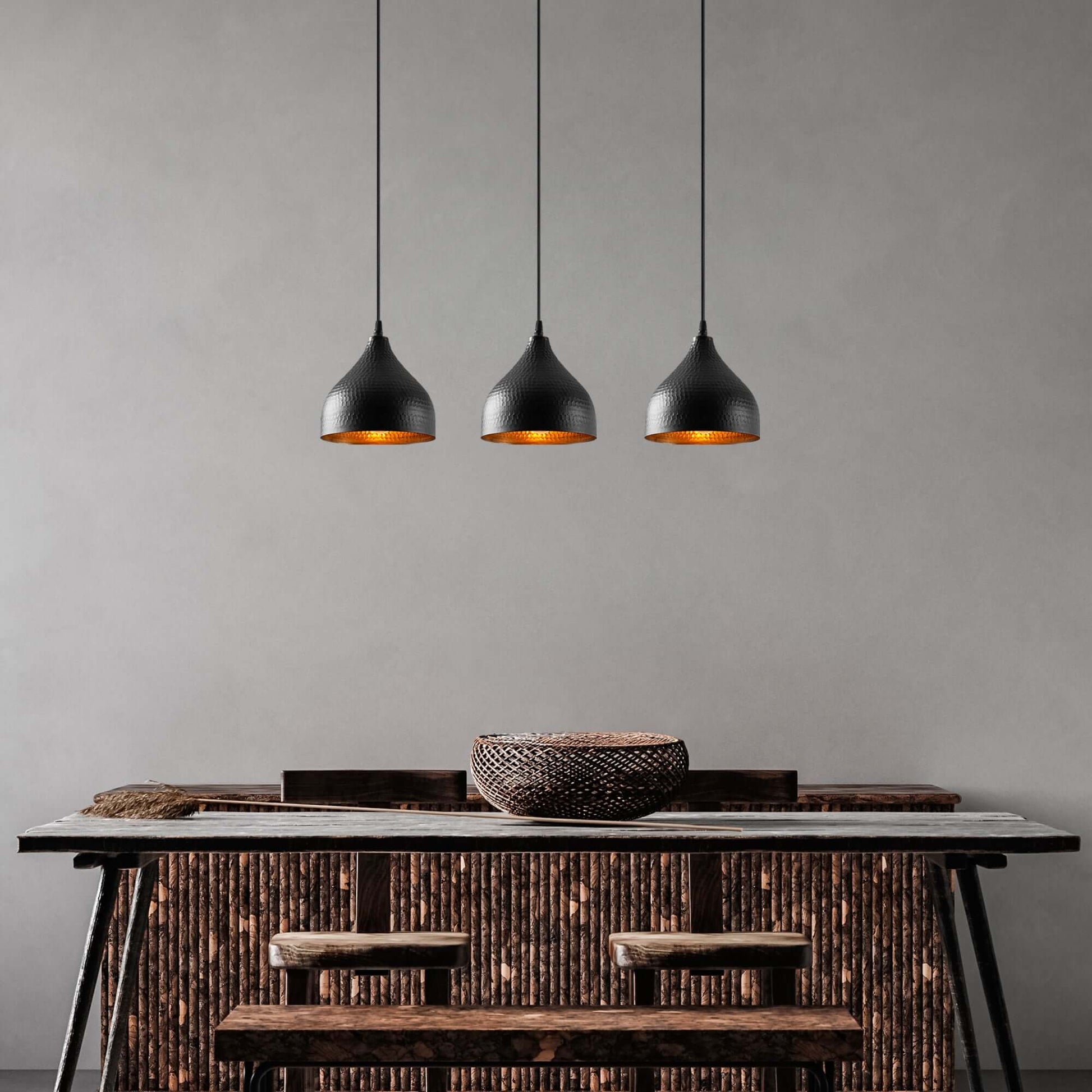 Elegant Industrial Ember Trio black pendant lights with warm amber glow for dining room, kitchen, or living space.