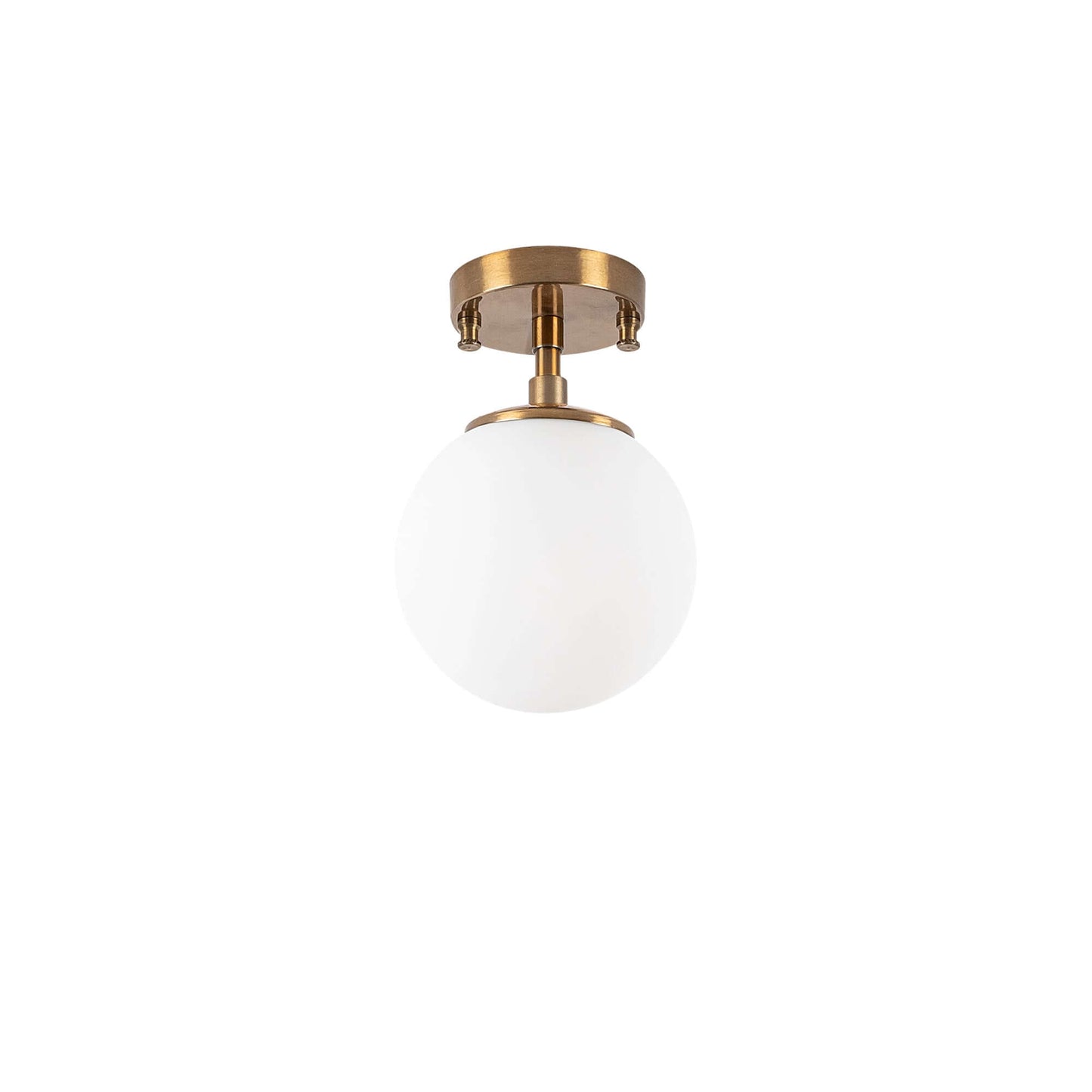 Frosted glass globe ceiling light with brass finish emitting soft glow.