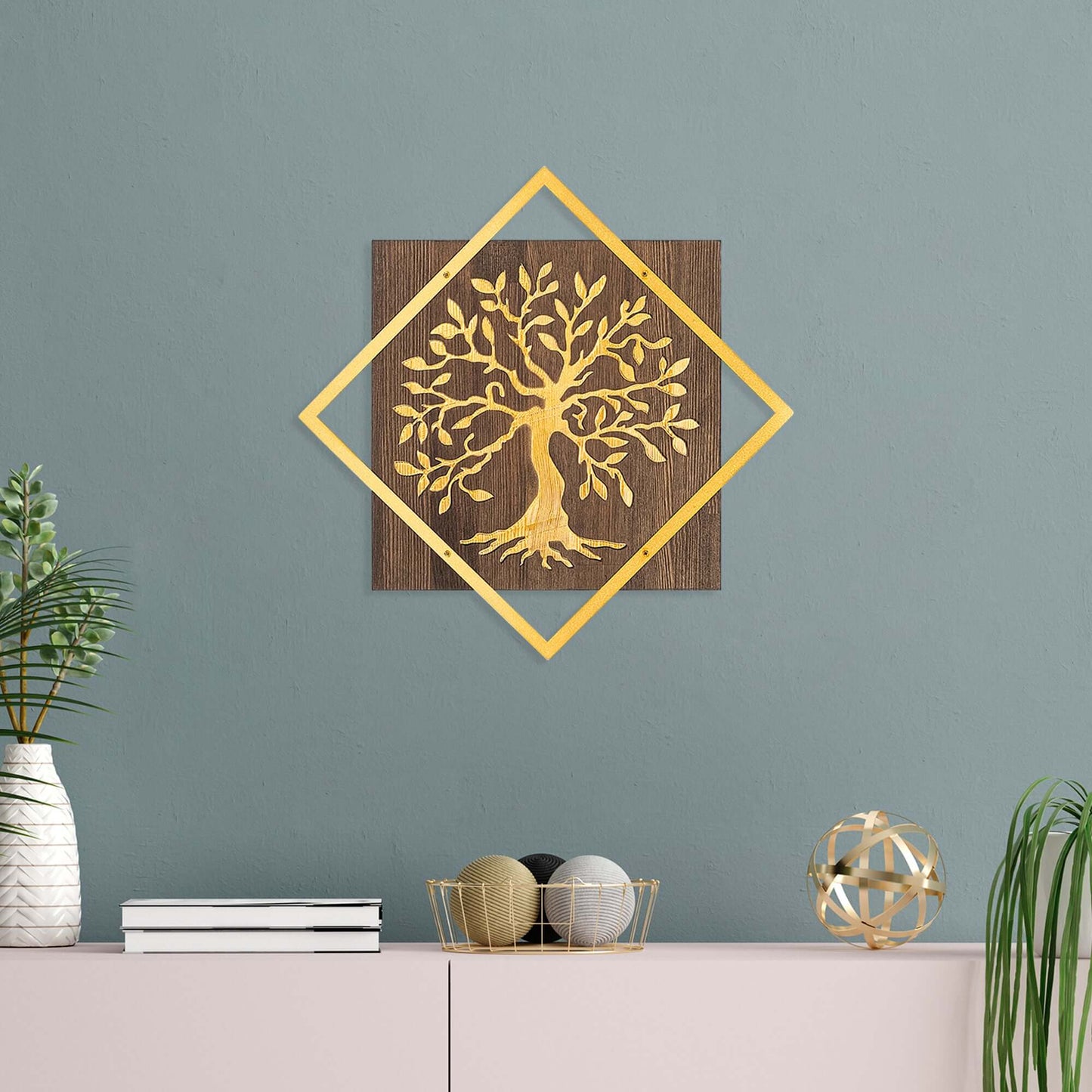 Golden metal tree wall decor on wood backing, adding warmth and nature's charm to living spaces.