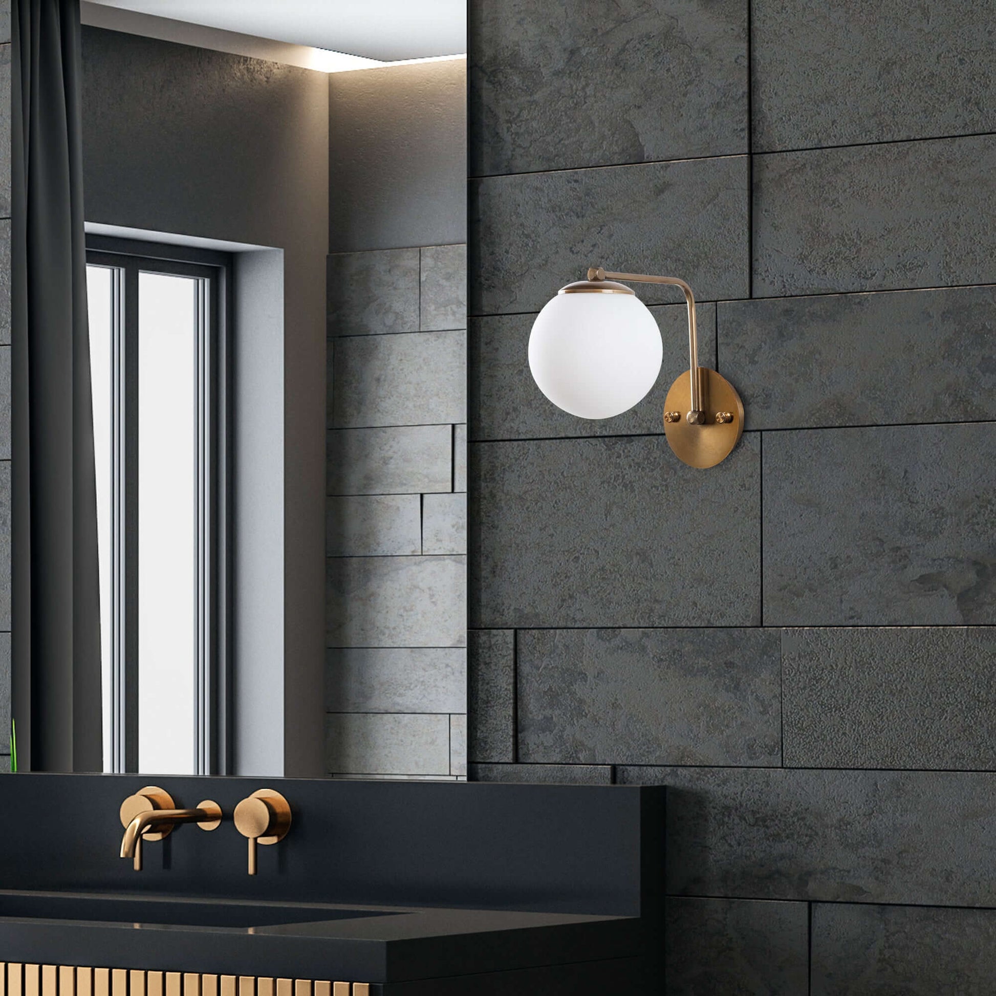 Modern brass wall sconce with orbital design pattern on wall.