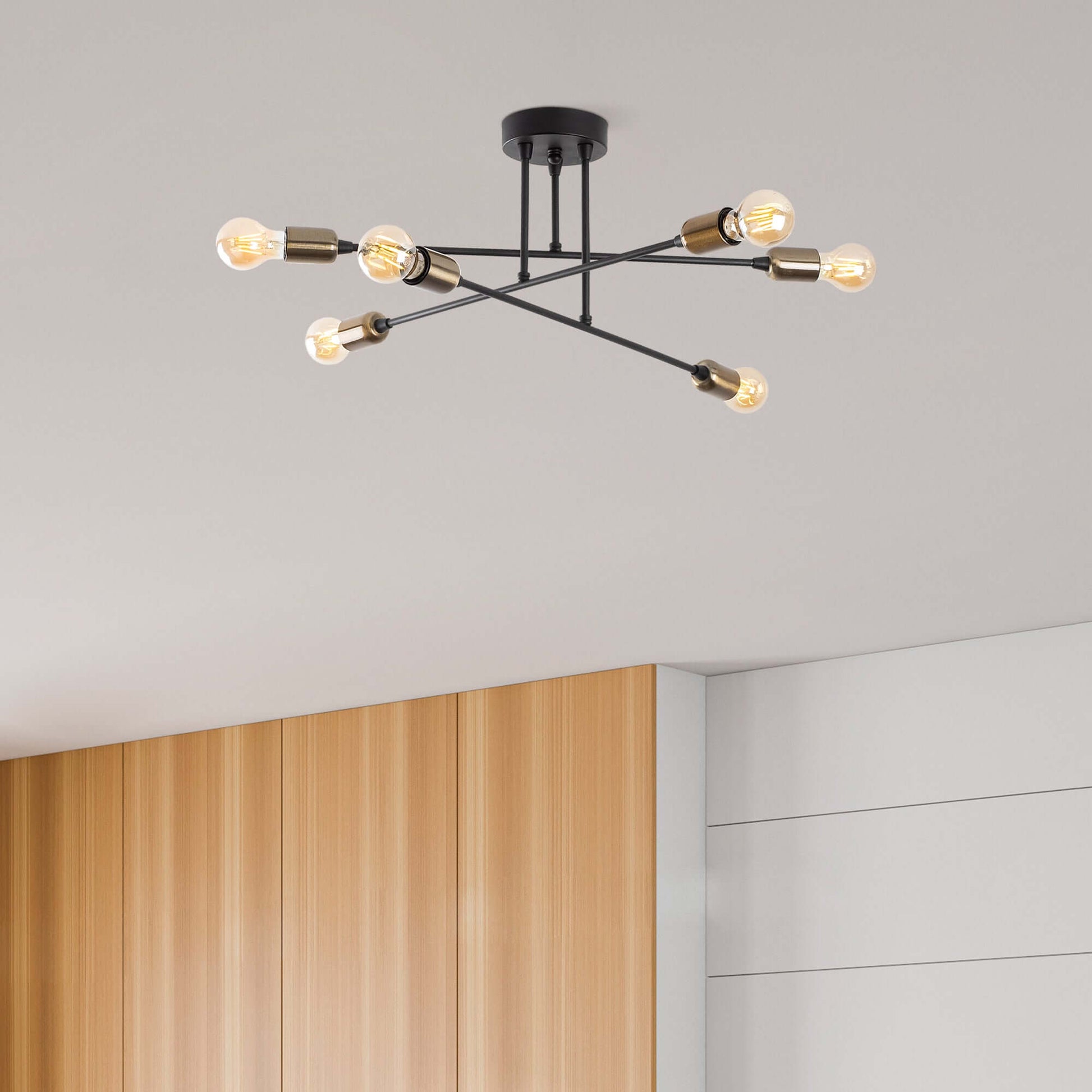 Contemporary star-shaped chandelier with exposed bulbs on black arms.